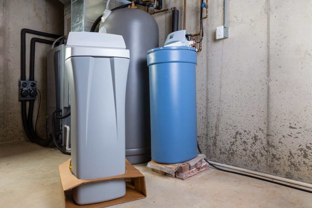 Old and new water softener tanks in a utility room