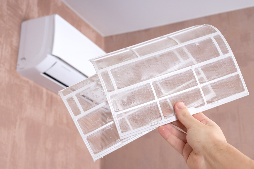 Air conditioner filter cleaning indoors.