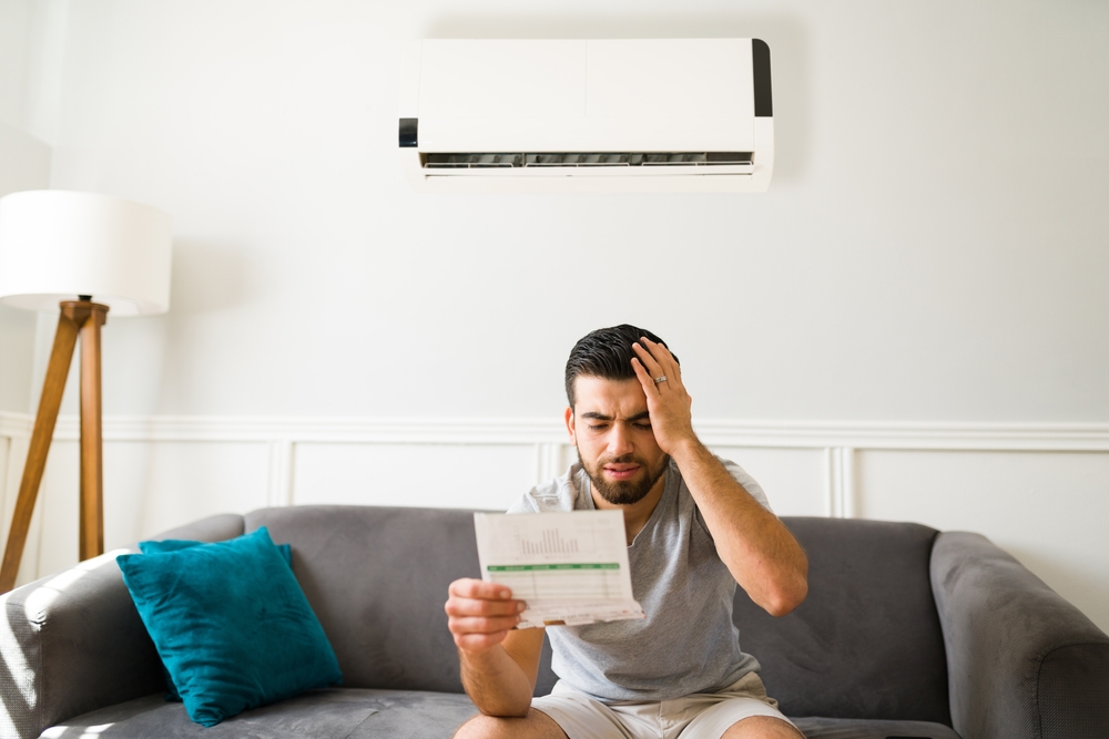 Stressed Latin man looking at his electric summer bills